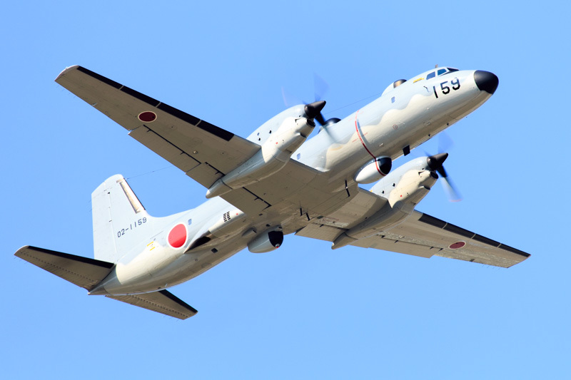 新田原基地を離れる観測機器を装備したプロペラ機